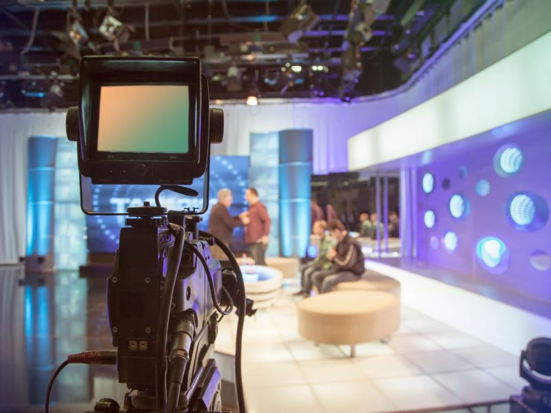 39273022 - television studio with camera and lights - recording tv show. shallow depth of field - focus on camera